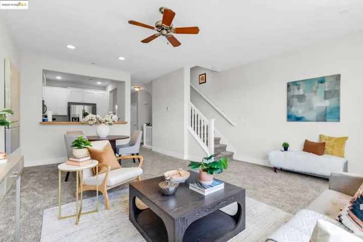 Living area with light carpet, stairs, recessed lighting, and a ceiling fan