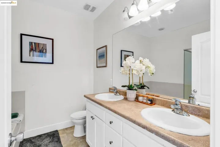 Full bath featuring double vanity and light tile patterned floors