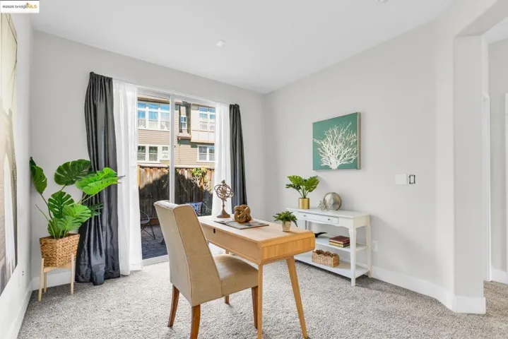 Home office with light carpet and baseboards