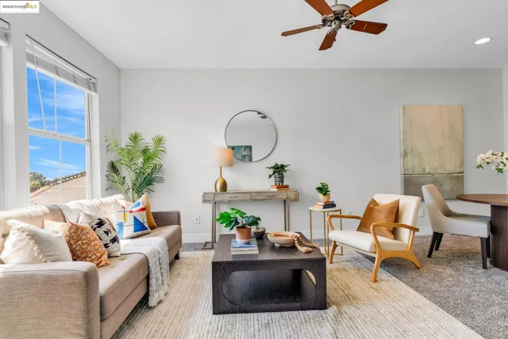Sitting room featuring a ceiling fan and carpet
