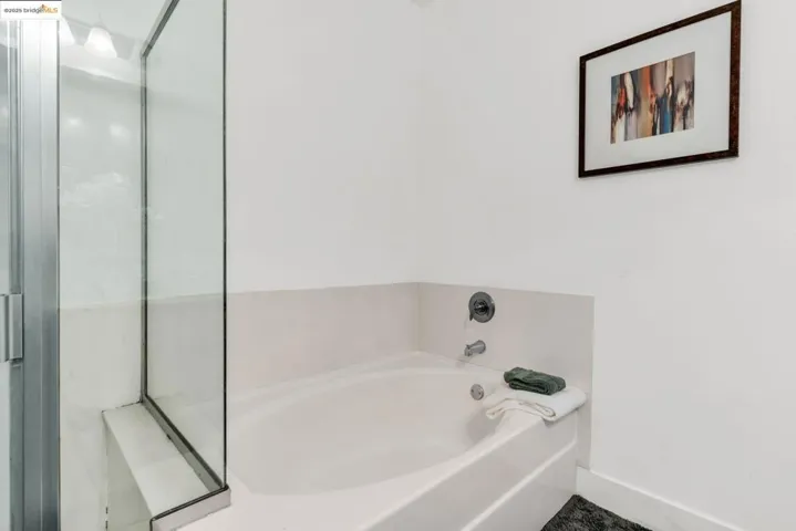 Full bathroom featuring a garden tub and baseboards