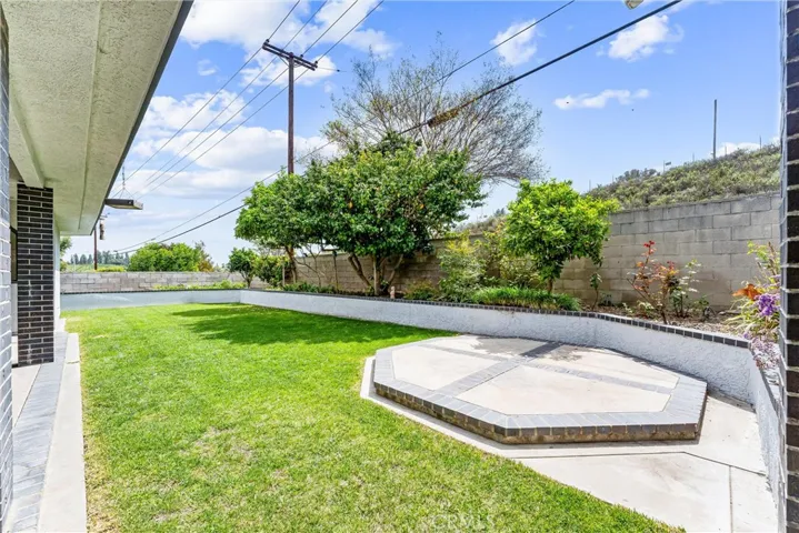A different vantage point of the raised pad and looking to the other side of the yard where the raised planter continue along the property wall.