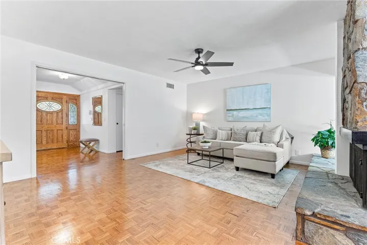 Family room view from the kitchen as well as a peek at the entry and front door.  See how those parquet floors shine.