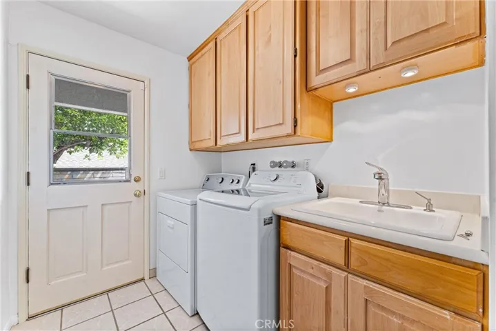 Next on the tour is a nice sized laundry room and a good sized utility sink.  Plus plenty of storage. And a door to the outside