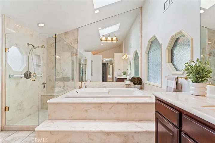 Back to the rest of the bathroom suite is the second vanity, a huge bath tub and a walk-in shower.  The toilet is in a separate space with a door for privacy.