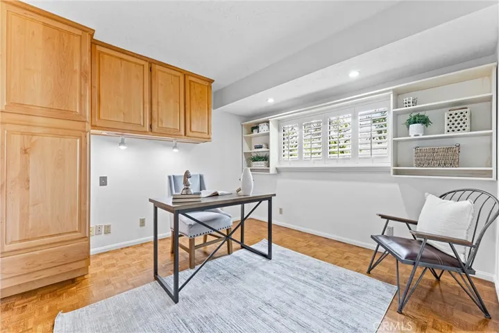 Now it is time to check out the home office with built in cabinetry and shelves   Lite many of the rooms, there are plantation shutters. Notice the continuous flow of parquet floors from the main living areas, down the hallways and into this room.