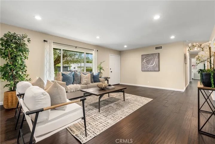 Another view of the living room. Recessed lighting and recently repainted throughout. The hallway to the bedrooms is in view to the right.