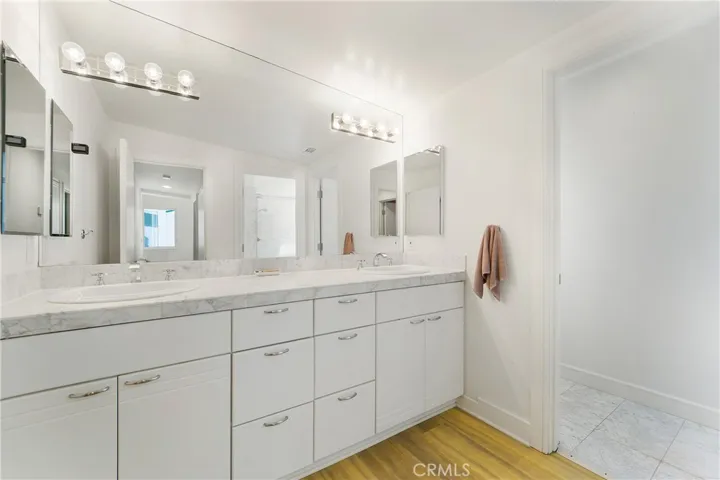 Upstairs secondary bath with dual vanities tub and shower as well as private stool.