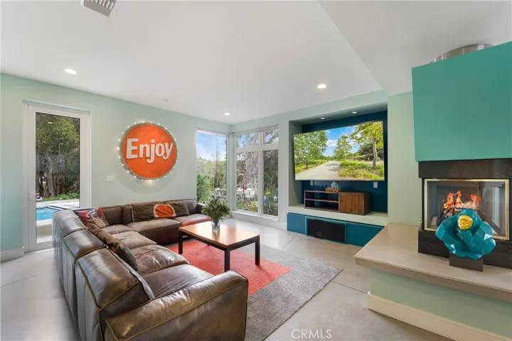 Family room which opens to kitchen. Three side fireplace warms the room.