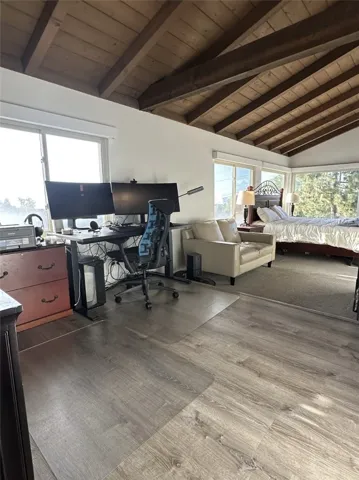 Landing at the top of the stairs, brightly lit with high ceilings and exposed beams.