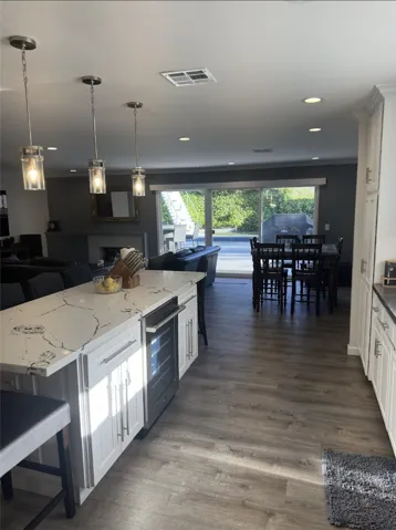 New wine refrigerator and kitchen island with breakfast bar.
