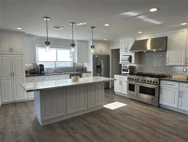 Kitchen completely remodeled with new countertops, backsplash, and high-end appliances.