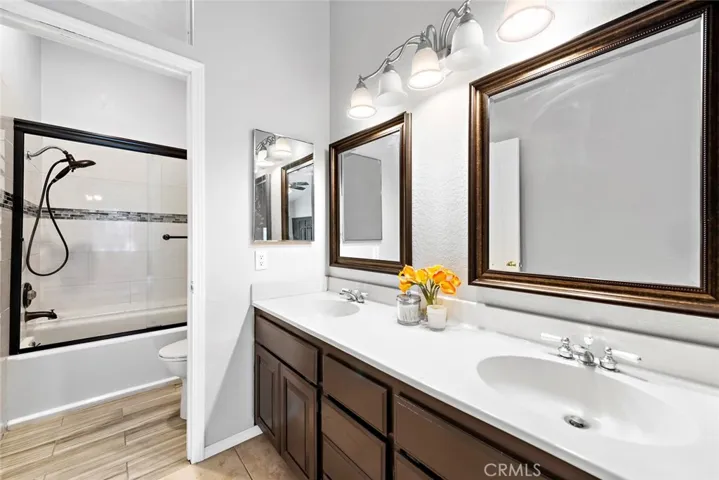 Primary Bathroom, Dual Sinks, large custom mirrors, Shower and tub, Tile flooring and beautiful sconces.  High Ceilings.  Clean Counter tops.