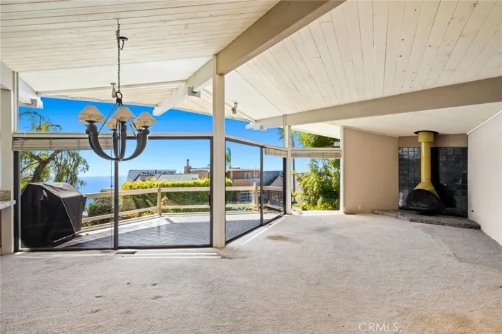 The main living area combines a spacious great room with a corner fireplace and a chef’s kitchen, all opening to a wide, sun-drenched balcony with ocean views.