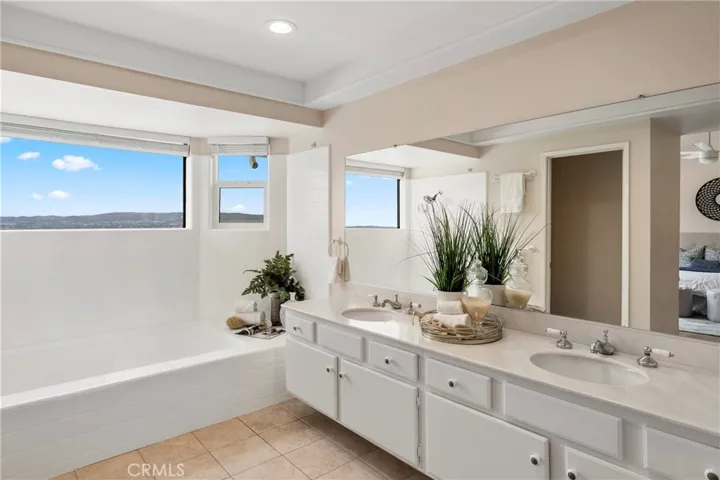 Primary bedroom with dual sinks and loads of natural light