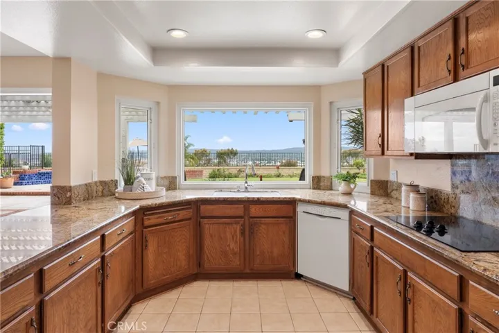 Picture window with two side windows thar open. Granite counters, Bosh dishwasher, electric cook top, microwave, pull out drawers in pantry cabinets