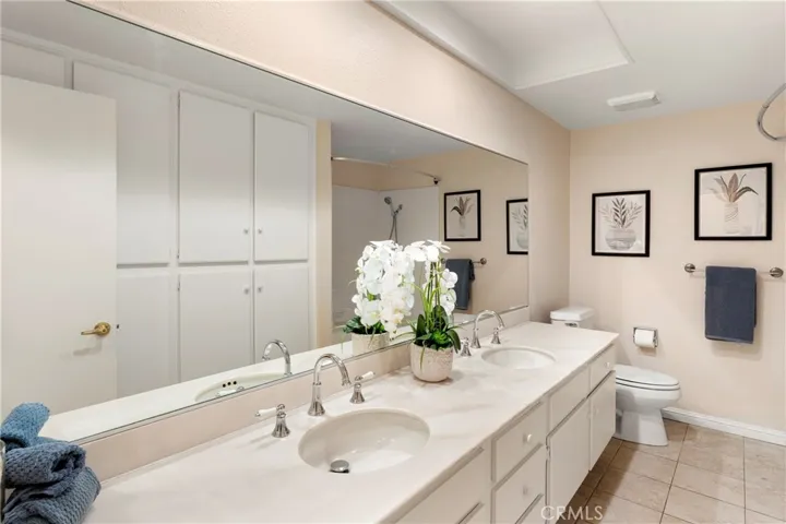 Hall bathroom with dual sinks, tub & shower plus loads of built-in cabinets for linens