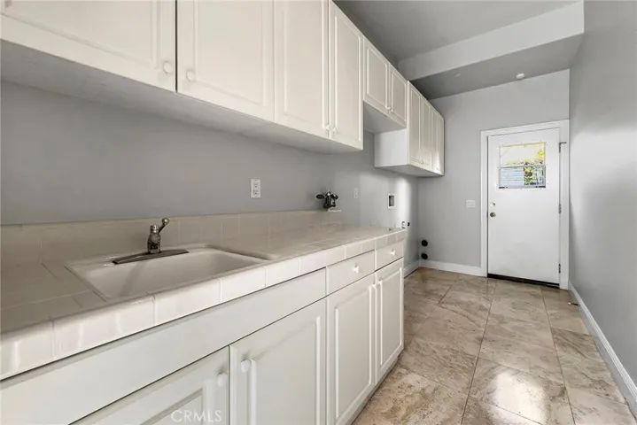 LAUNDRY ROOM WITH A UTILITY SINK AND LOTS OF CABINETS