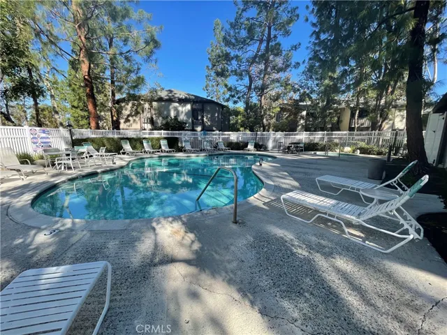 Community pool and spa area, lined with trees and streams