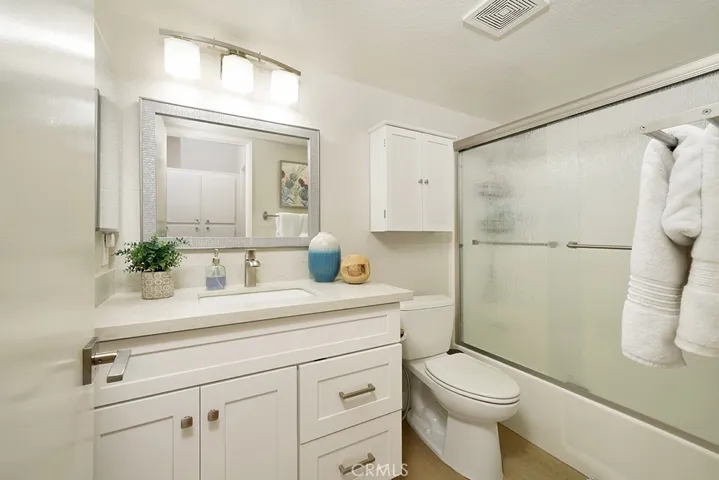 Spacious bathroom with upgraded quartz countertops, soft close cabinets and vinyl wood flooring.