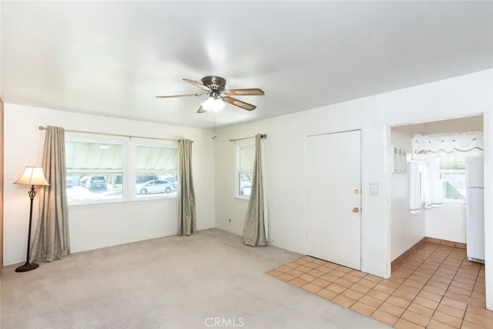 Living Room entry with vinyl dual paned windows and ceiling fan