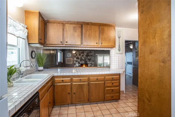 Real Wood Cabinetry with tiled countertops, breakfast bar and picturesque window at sink area