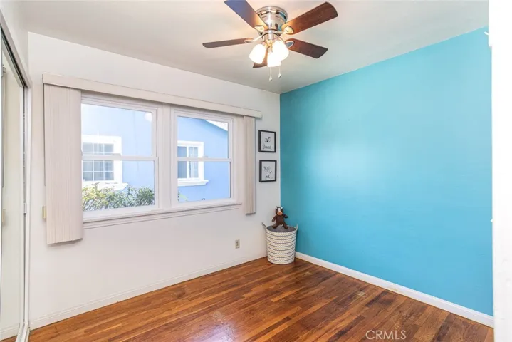 Bedroom with real wood hardwood flooring, dual paned windows + ceiling fan