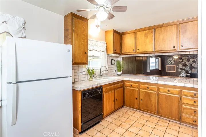 Real Wood Cabinetry with tiled countertops, breakfast bar and picturesque window at sink area