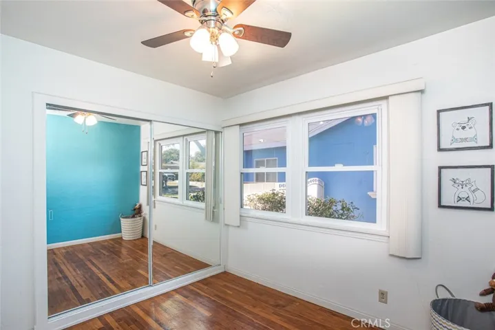 Real wood flooring with dual paned windows + ceiling fan, newer interior paint, mirrored wardrobe doors