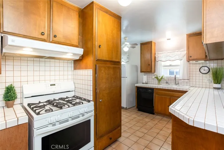 Real Wood Cabinetry with tiled countertops, breakfast bar and picturesque window at sink area