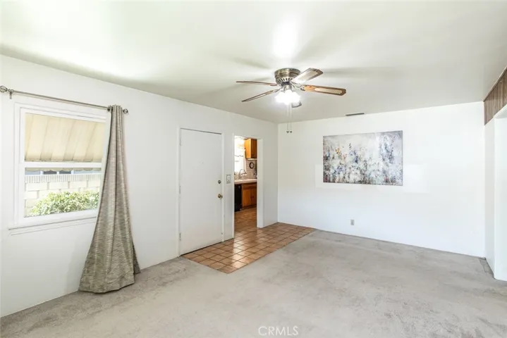 Living Room entry with vinyl dual paned windows and ceiling fan