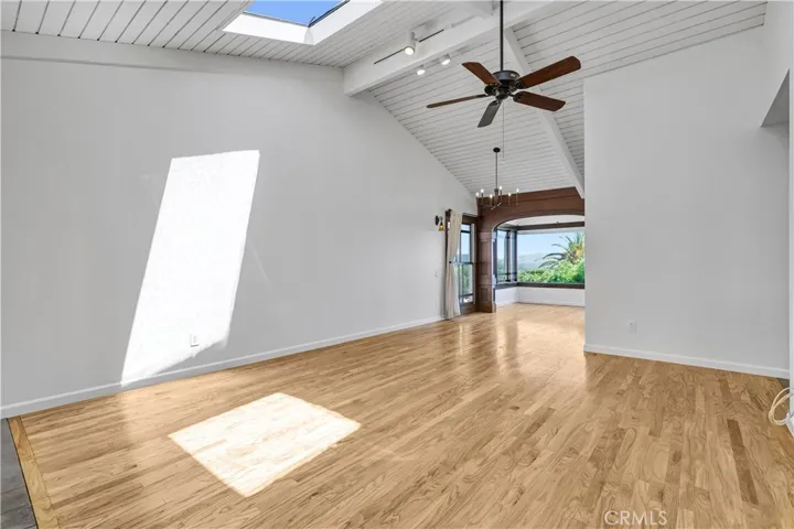 Living room with tongue and groove wood vaulted ceiling with 2 skylights and a fireplace