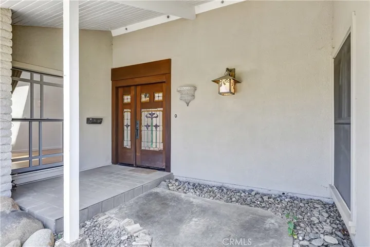Welcoming covered front porch with custom wood and glass entry door