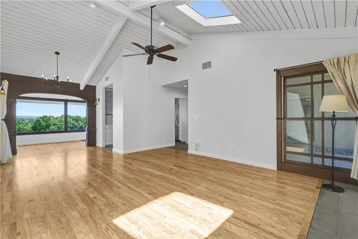 Living room with tongue and groove wood vaulted ceiling with 2 skylights and a fireplace