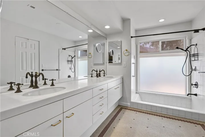 Modern bath with enormous dual sink vanity, slightly sunken tub/shower with abundant natural light from the floor to ceiling window