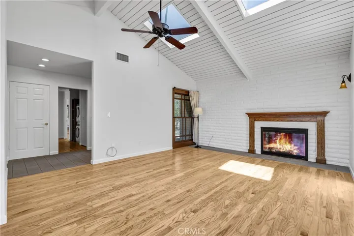 Living room with tongue and groove wood vaulted ceiling with 2 skylights and a fireplace