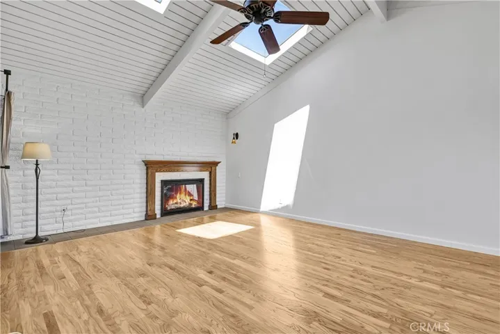 Living room with tongue and groove wood vaulted ceiling with 2 skylights and a fireplace