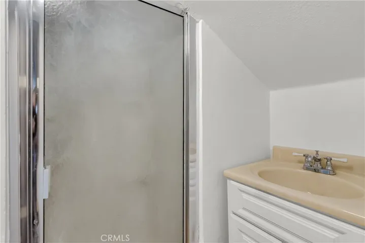 Alternate view of upstairs bathroom with vanity and shower. l