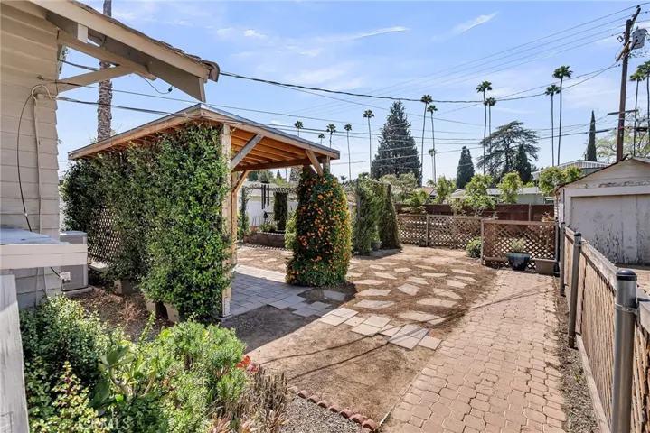 View from basement entrance to the pool-sized backyard and vintage garage.