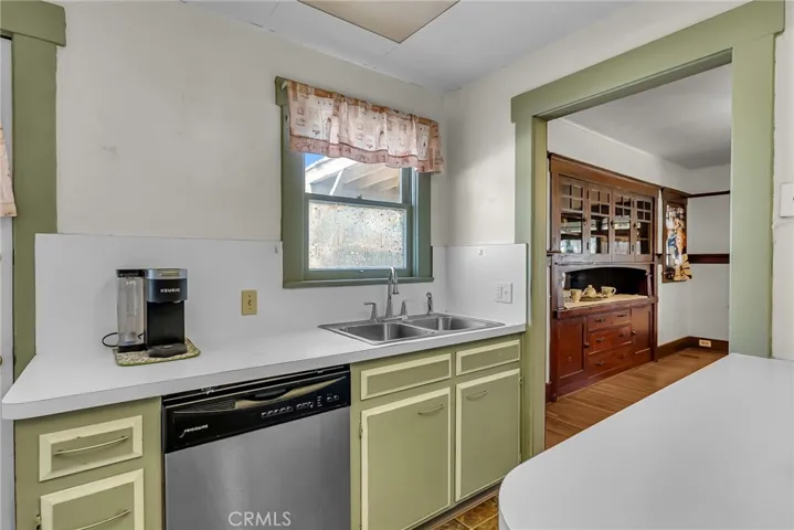 Peekaboo view of the formal dining room hutch from the cozy kitchen (with dishwasher).