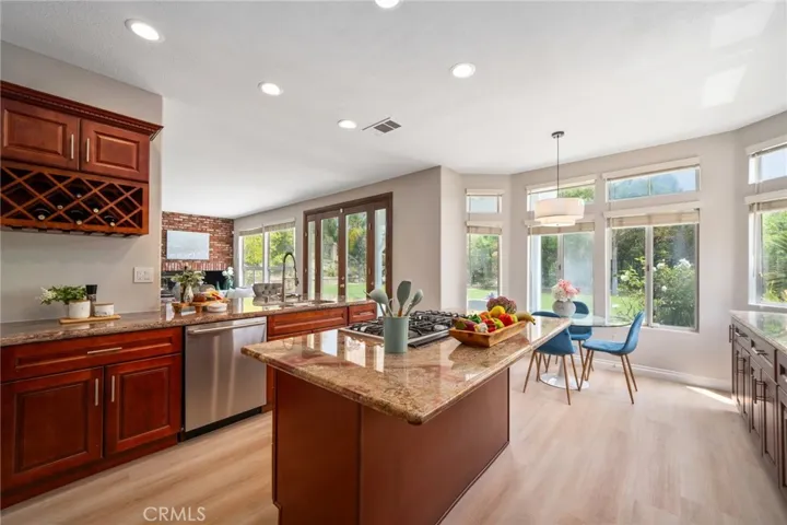 The upgraded gourmet kitchen is a chef’s dream, showcasing granite countertops, center island, newer cabinetry, recessed lighting, new stainless steel appliances, and a breakfast bar