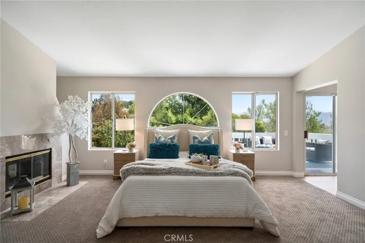 The expansive primary suite is a private retreat, featuring high ceilings, the third fireplace, private lounge area, and balcony