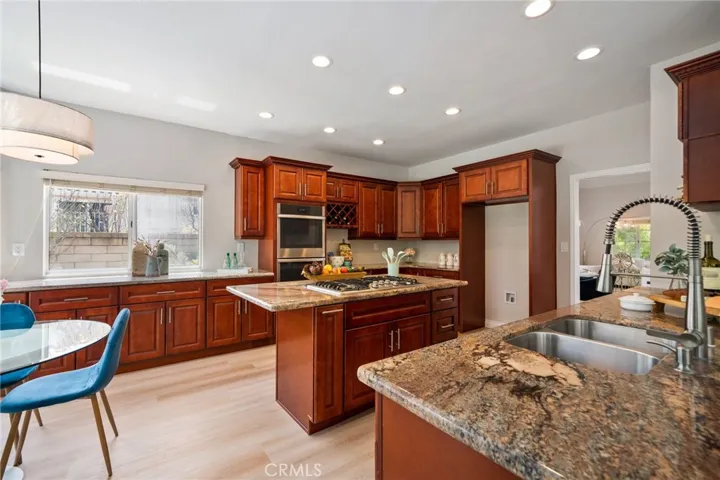 The upgraded gourmet kitchen is a chef’s dream, showcasing granite countertops, center island, newer cabinetry, recessed lighting, new stainless steel appliances, and a breakfast bar