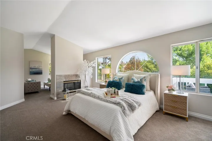 The expansive primary suite is a private retreat, featuring high ceilings, the third fireplace, private lounge area, and balcony.
