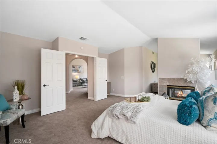 The expansive primary suite is a private retreat, featuring high ceilings, the third fireplace, private lounge area, and double door entry