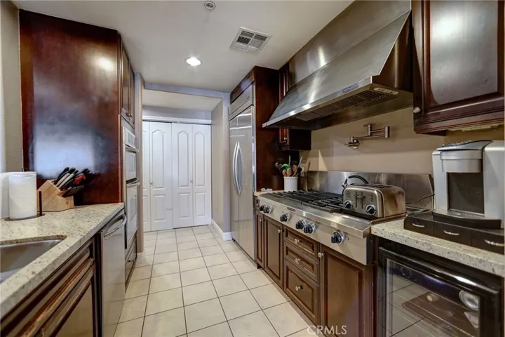 Kitchen has a commercial stove & hood, stainless steel appliances