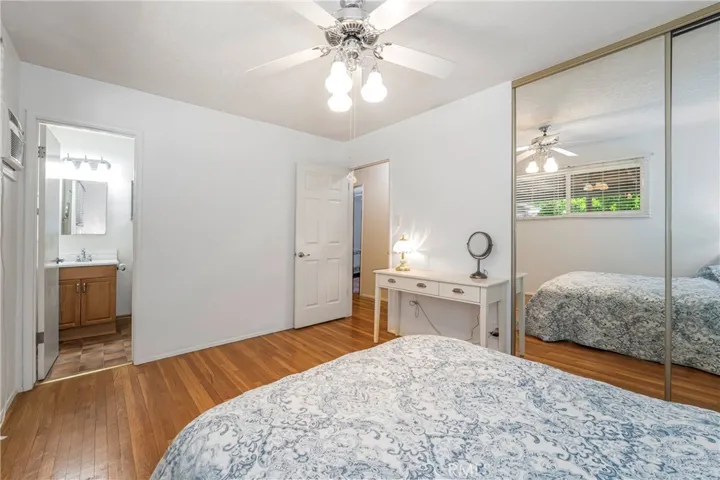 Primary bedroom with spacious closet with mirrored door and private bathroom