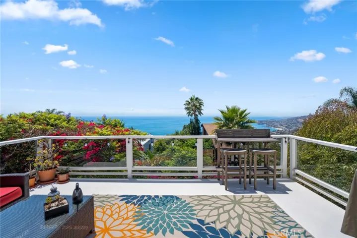 An open-concept layout seamlessly connects the living and dining rooms to an expansive entertainer’s deck, where panoramic ocean vistas take center stage.