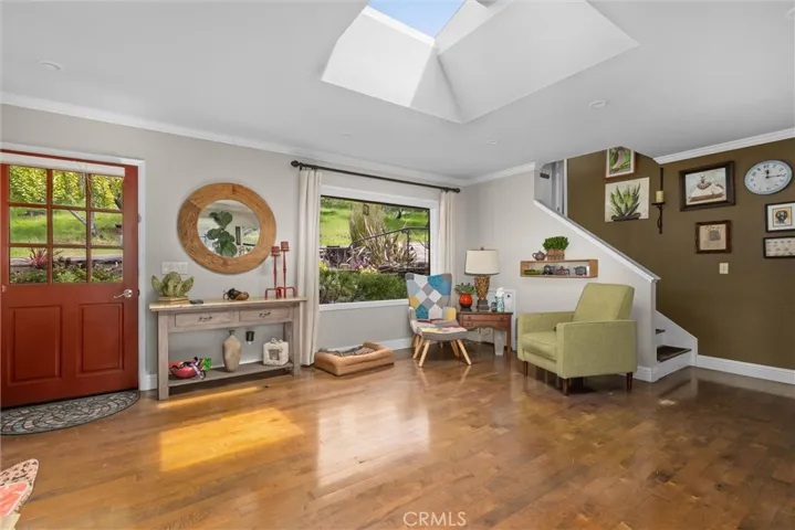Other view of living room, showing stairs to primary suite over garage.