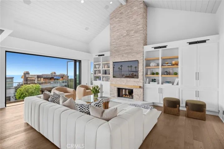 The main level is introduced by a large living room with vaulted ceiling and a stacked-stone fireplace flanked by custom built-ins.